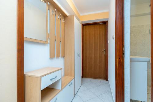 a dressing room with wooden cabinets and a door at Apartments with parking space Mrljane, Pasman - 20056 in Pašman