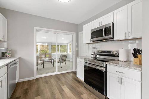 a kitchen with white cabinets and a black stove top oven at Stylish, Relaxing & Comfy 3 BDR Home in Bristol