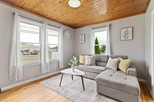 a living room with a couch and two windows at Stylish, Relaxing & Comfy 3 BDR Home in Bristol