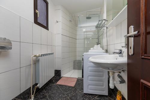 a white bathroom with a sink and a mirror at Apartments for families with children Karlovac - 20989 in Karlovac