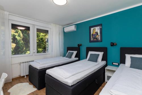 Duas camas num quarto com paredes azuis em Apartments with WiFi Karlovac - 20990 em Karlovac