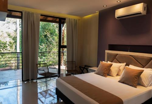 a bedroom with a large bed and a balcony at Tekoa Lodge in Puerto Iguazú