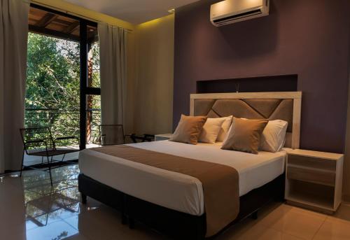 una camera con un grande letto e un balcone di Tekoa Lodge a Puerto Iguazú