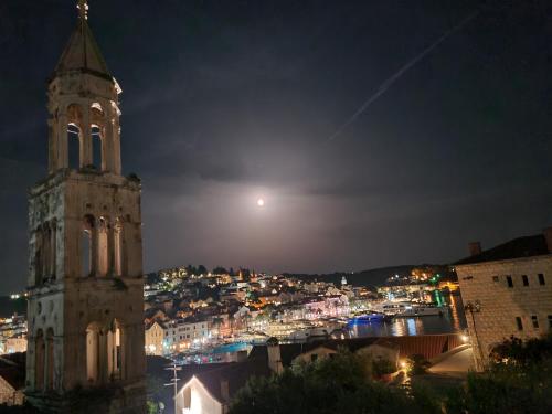 a large building with a clock tower at night at House La Vista Hvar in Hvar
