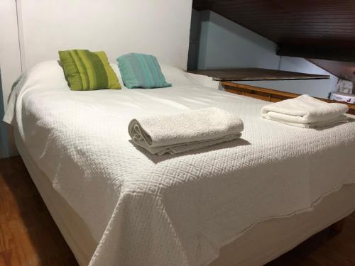 Una cama blanca con dos toallas encima. en Dto tres personas mas elegido wifi libre-acepta mascotas-parrilla-piscina-reposeras-terraza solarium en Mar del Plata