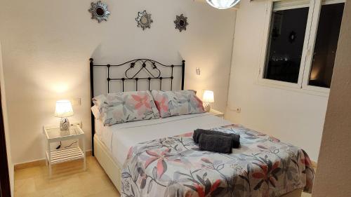 a bedroom with a bed with a black headboard at 2BDR Sunny apartment with pool and private parking in Benalmádena in Benalmádena