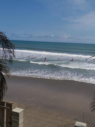 a group of people in the waves in the ocean at KorKoCove Beachfront Suites in Accra