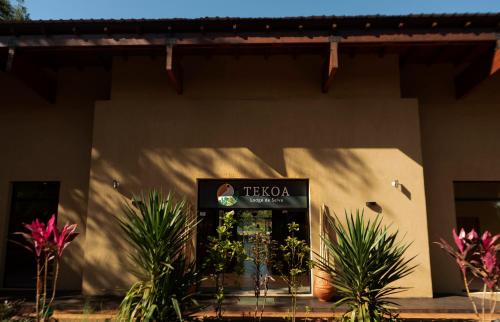 una señal en el lado de un edificio con plantas en Tekoa Lodge en Puerto Iguazú