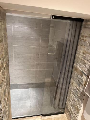 une douche avec une porte vitrée dans une salle de bain dans l'établissement la brigantine 2, à La Ciotat