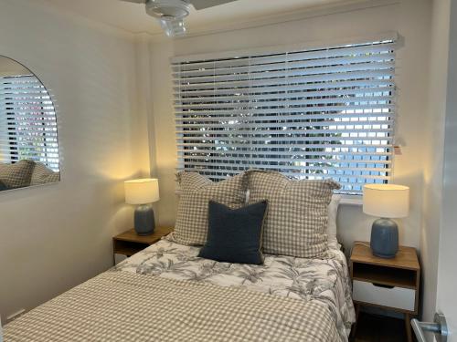 a bedroom with a bed with two lamps and a window at Comfortable Seaside Studio & Courtyard in Scarborough