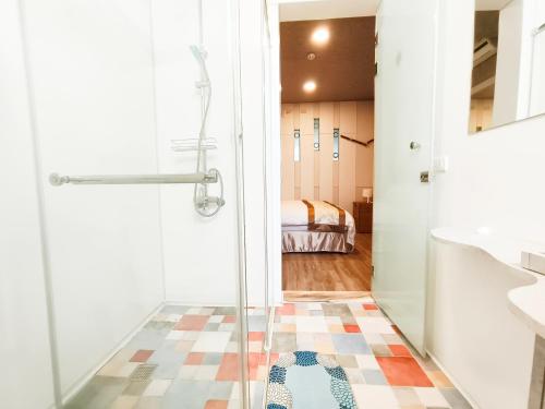 um banheiro com chuveiro e porta de vidro em Yu Hsuan Homestay em Taitung City