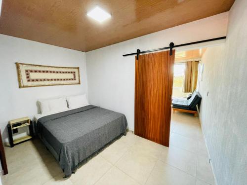 a bedroom with a bed and a sliding glass door at Ubud Apartments Praia do Frances in Praia do Frances