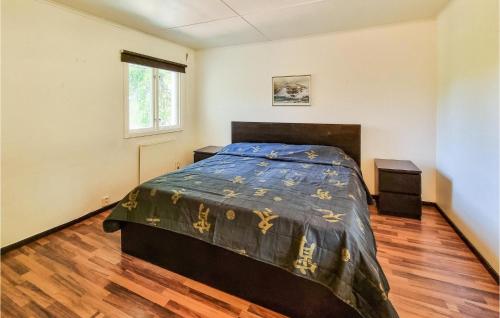 1 dormitorio con 1 cama y suelo de madera en Nice Home In Grbo With Jacuzzi en Gråbo