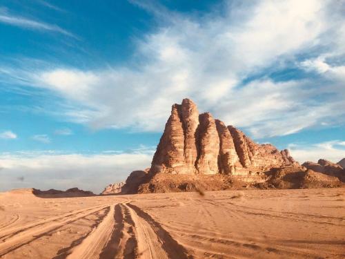 uma formação rochosa no deserto sob um céu nublado em وادي رم يوسف em Wadi Rum