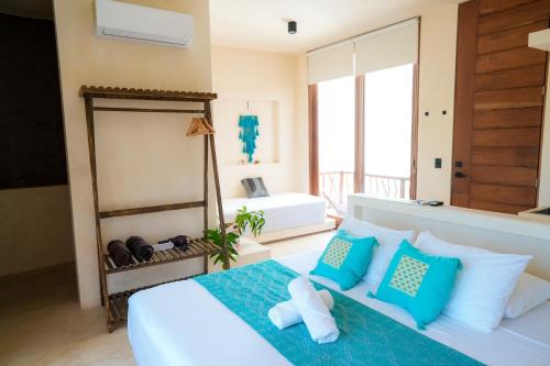 um quarto com uma cama com almofadas azuis e brancas em Tikul Hotel Boutique em Holbox