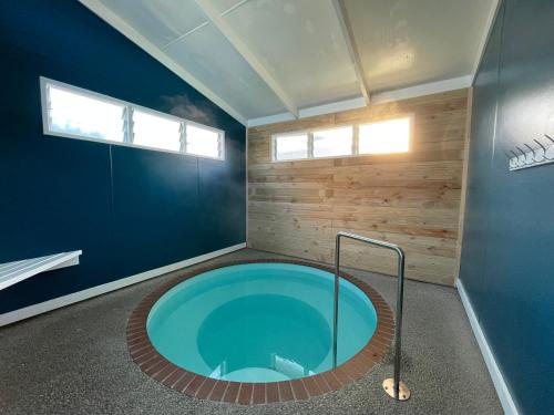 uma banheira de hidromassagem num quarto com uma parede azul em Holdens Bay Holiday Park em Rotorua