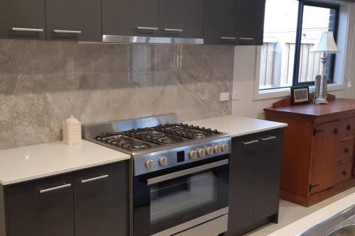 a kitchen with a stove and a counter top at Homely and newly built place with a lot to do. in Beaconsfield