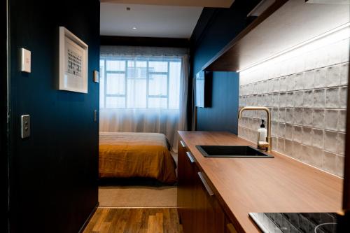 una cocina con fregadero y una cama en una habitación en The Cobbler Hotel, en Wellington