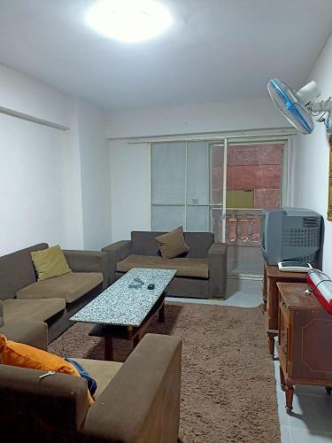 a living room with a couch and a table and a tv at ستوديو للايجار اليومي in Alexandria