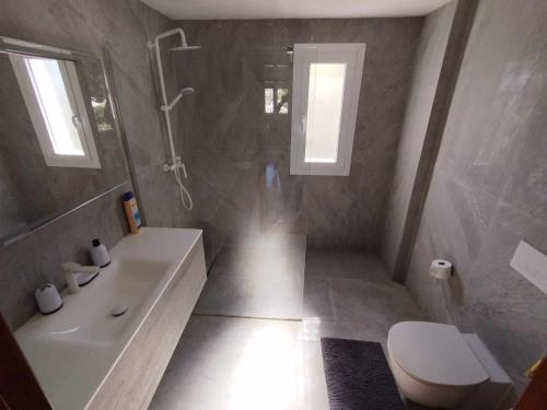 a bathroom with a shower and a toilet and a sink at Casa Las Emilias en La Cañada in Partida de La Cañada