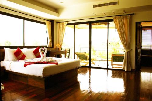 um quarto com uma cama e uma varanda com portas de vidro deslizantes em chawenglakeviewcondo em Koh Samui 