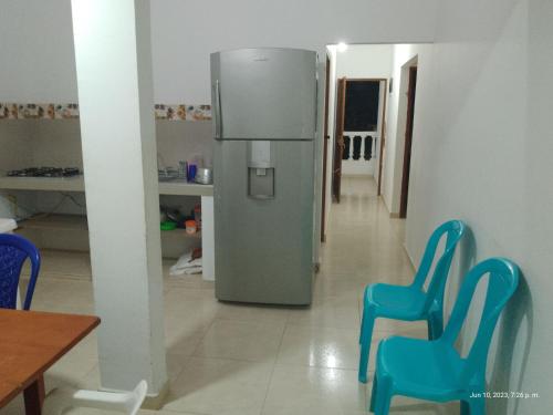 een keuken met blauwe stoelen en een koelkast bij Casa Shangai 3 in Santa Marta