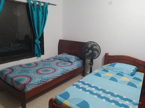 1 dormitorio con 2 camas y ventilador en Casa Shangai 3, en Santa Marta
