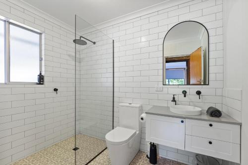 a white bathroom with a toilet and a sink at Valley House in Margaret River Town