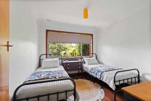 two beds in a room with a window at Valley House in Margaret River Town