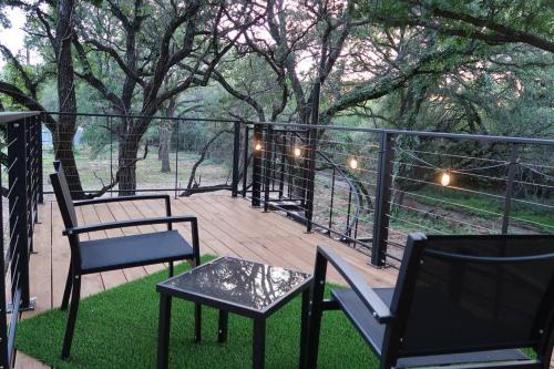 a patio with two chairs and a table on a deck at The Tiny 'Tainer - Tiny Container Home w. Hot Tub! in Weatherford