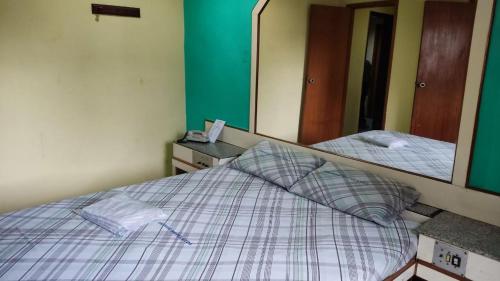 a bedroom with a bed and a mirror at Grande Hotel in Duque de Caxias