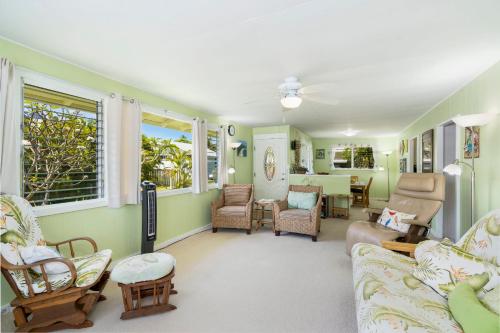 a living room with green walls and furniture and windows at Last Minute Deal! Stunning 2-Bedroom Beachfront House with AC in Kailua