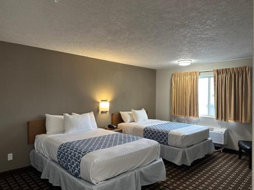a hotel room with two beds and a window at Rodeway Inn & Suites North Sioux City I-29 in North Sioux City