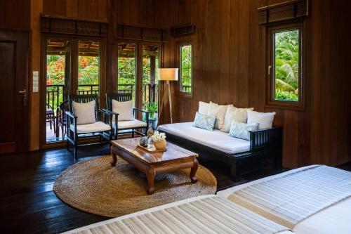 a living room with a bed and a coffee table at Farmhouse Resort & Spa in Kampong Chhnang