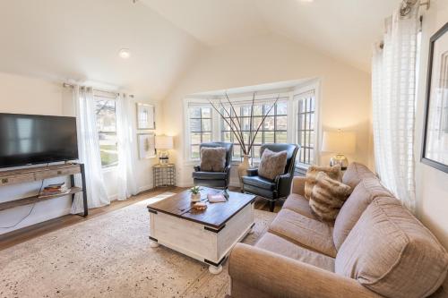 a living room with a couch and a tv at Luxurious Historic Renovated Bungalow DT Rapid City with Private Patio in Rapid City