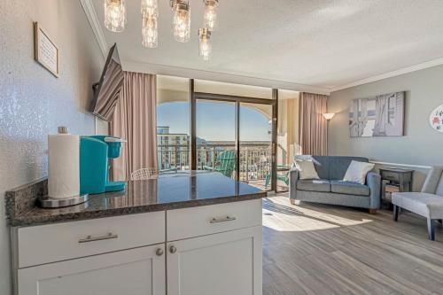 a kitchen with a counter top and a living room at Beautiful Ocean views, on 15th floor! in Myrtle Beach