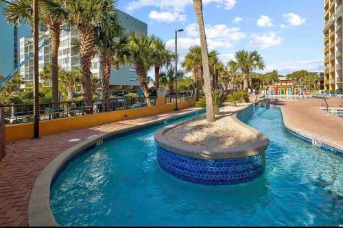 a swimming pool with a palm tree in the middle at Beautiful Ocean views, on 15th floor! in Myrtle Beach