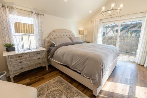 1 dormitorio con 1 cama, vestidor y ventana en Luxurious Historic Renovated Bungalow DT Rapid City with Private Patio, en Rapid City