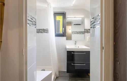 a bathroom with a sink and a toilet and a mirror at Beautiful Home In Les Angles With 3 Bedrooms, Wifi And Outdoor Swimming Pool in Les Angles Gard