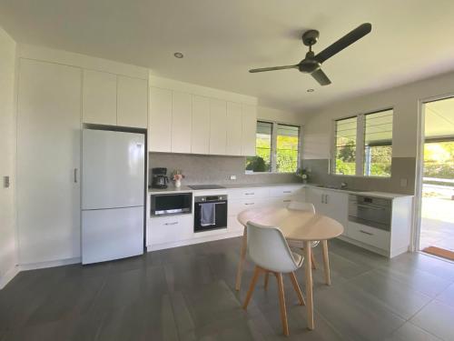 a kitchen with a table and a white refrigerator at Ranch Retreat in Kewarra Beach