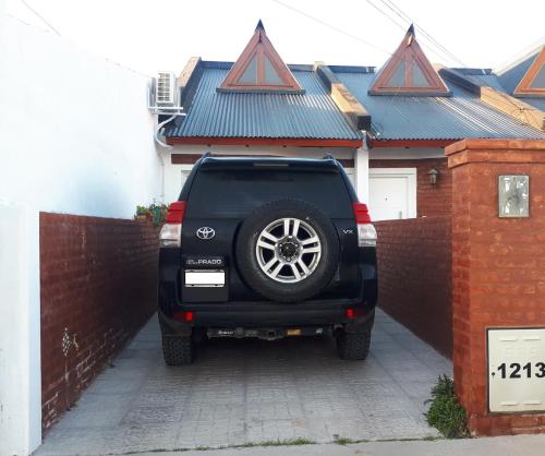 a black car parked in front of a fence at Ensueños in Trelew