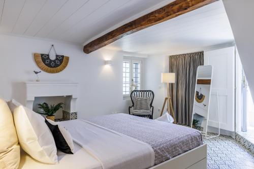 Dormitorio blanco con cama y chimenea en Swift View, en Panormos Skopelos