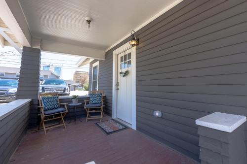 a porch of a house with two chairs and a table at Modern Luxury Bungalow steps from DT Activities in Rapid City