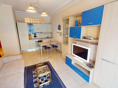 un salon avec un canapé et une télévision et une cuisine dans l'établissement Agréable 2P moderne en centre-ville, proche mer avec balcon, Menton - FR-1-196-333, à Menton