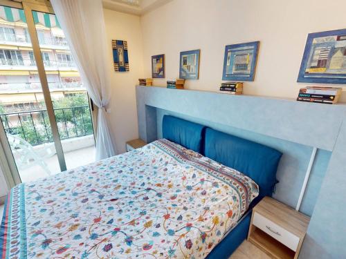- une chambre avec un lit doté d'une tête de lit bleue et d'une fenêtre dans l'établissement Agréable 2P moderne en centre-ville, proche mer avec balcon, Menton - FR-1-196-333, à Menton