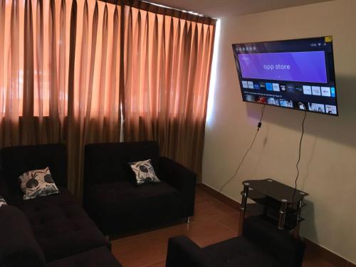 a living room with a couch and a flat screen tv at 821 Céntrico Departamento en Chorrillos in Lima