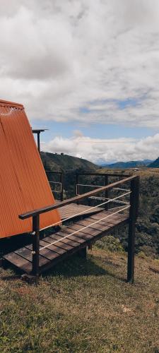 een houten bank bovenop een heuvel bij La Bella Finca Hostal-Lodge in Villamaría
