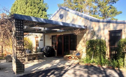 Casa blanca pequeña con porche delantero en Willow Cottage, en Kurrajong