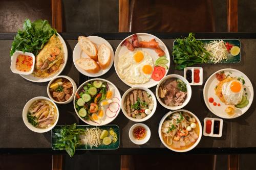 a table topped with plates of food on a table at Tuong Boutique Resort Mui ne in Mui Ne