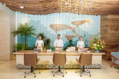 a group of men standing around a table with laptops at Seaesta Nha Trang Hotel in Nha Trang